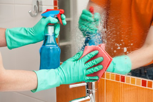 Professional cleaner working on kitchen surfaces in a Barnet home